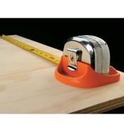 Tape measure in a stand being used to measure plywood