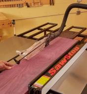 Rip cutting a long board on a table saw, using the folding outfeed table for support