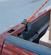Tie-down anchor clamped to the rail of a pickup truck, with a rope tied to the hook