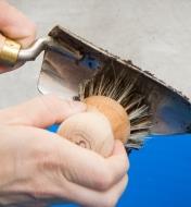 Using the scouring brush to clean a trowel