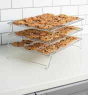 Cooling racks stacked in three tiers with each rack covered in cookies
