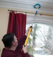 Using the 2' to 3 1/2' Extension Pole and a duster attachment to clean crown molding