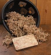 Compressed Sphagnum Moss packet in front of a basket filled with expanded moss