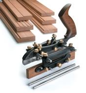 Veritas Combination Plane in front of a pile of boards with various cuts