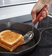 Using a Vintage-Design Slotted Spatula to flip a grilled cheese
