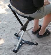 A woman sits on a Walkstool Comfort with the Walkstool Steady attached, sold separately.