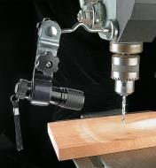 Flashlight holder affixing a flashlight to a drill press