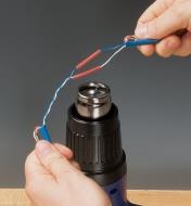 Using a variable heat gun to heat shrink tubing to connect electrical wire 