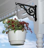 Black Victorian Wall Bracket holding a hanging basket on an outdoor post