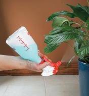 Spraying a plant with the sprayer held upside down