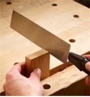 Using a Veritas Dovetail Saw to cut into a board held in a workbench vise