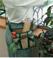 A woman wearing a 4-Pocket Tool Pouch and Belt in a greenhouse