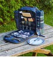 An open Deluxe Picnic Backpack sitting on a picnic table