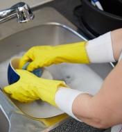 Wearing glove liners under rubber gloves while washing dishes