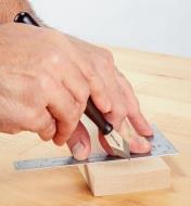 Using a Striking Knife to cut a line across a small board