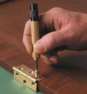Using a Self-Centering Punch to mark a drill hole for installing a hinge
