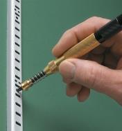 Using a Long-Nose Center Punch to mark the wall behind a wall standard