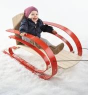 Suspension Sled holding a toddler is pulled over snow by the tow rope