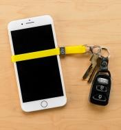 Cinch-A-Lot Stretch Strap wrapped around a cell phone and attached to a keychain