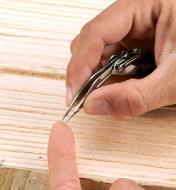 Removing a sliver from a finger with Fold-Out Tweezers