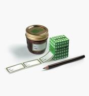 Box of dissolvable labels next to a jam jar and a pencil