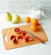 A knife and a sliced orange on a Large Epicurean Prep Series Cutting Board