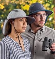A woman and man wearing adventure sun hats while birdwatching