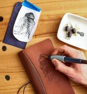 Burning a jellyfish design onto a leather notebook cover