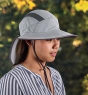 Side view of a woman wearing a light gray adventure sun hat