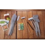 Hairpin markers and regular markers piled on a potting bench next to seed packets and a pencil