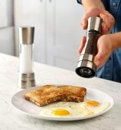 Using a Cole & Mason pepper mill to add fresh-ground pepper to a plate of fried eggs