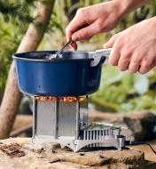 Poignée pour casserole de camping utilisée pour maintenir une casserole sur le feu en brassant