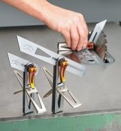 Small and large multi-tools on display with with a small one in the background being used to set a table saw blade at an angle 