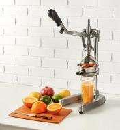 Juice Press on a counter being used to squeeze a glass of orange juice