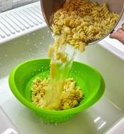 Large collapsible colander used to drain pasta from a pot