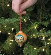 Hanging a First Catalog Ornament on a Christmas tree