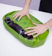 Personne frottant le contenu d'un sac lave-linge Scrubba contre sa planche à laver en silicone