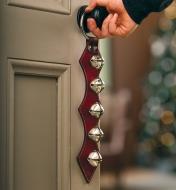 La décoration de porte en cuir à 5 grelots accrochée au bouton d’une porte