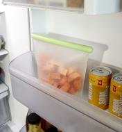 1000ml Reusable Silicone Bag filled with sweet potato pieces in the door shelf of a refrigerator