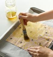 Brushing wax on to a cloth to create a beeswax wrap