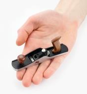The miniature bevel-up jack plane sits on an open hand