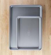 A quarter sheet baking pan nested in a half sheet baking pan to compare size