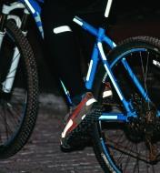 Peel-and-stick reflective strips applied to a bicycle, shoes and clothing