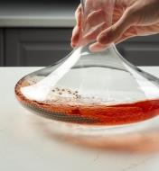 Swirling the beads in the bottom of a stained wine decanter