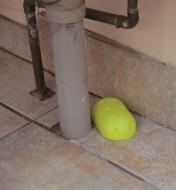 Earwig Trap placed on a floor beside a pipe
