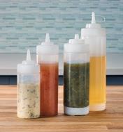 Four squeeze bottles filled with condiments