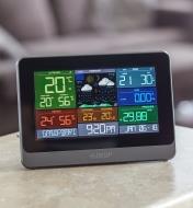 The display unit of the Wi-Fi weather station with wind and rain sits on a tabletop