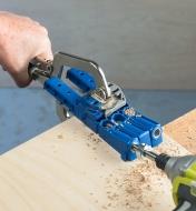 A Kreg 320 pocket-hole kit being used to drill pocket holes in a piece of wood