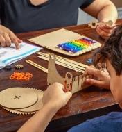 A young person and an adult helper assemble the xylophone music machine kit