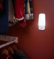 LED wall sconce illuminated inside a closet